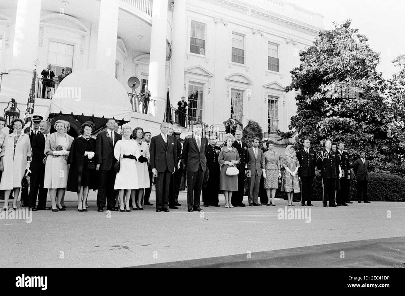President Kennedy greets recipients of the Congressional Medal of Honor, Annual Military Reception, 6:03PM. President John F. Kennedy and others attend a military reception in honor of recipients of the Congressional Medal of Honor. Left to right: several unidentified persons; Margaret McNamara (wearing black coat), wife of Robert S. McNamara, Secretary of Defense; Secretary McNamara; Secretary of the Navy, Fred Korth (behind McNamara); Madelin T. Gilpatric, wife of Roswell L. Gilpatric, Deputy Secretary of Defense; Phyllis Chess Ellsworth, wife of C. Douglas Dillon, Secretary of the Treasury; Stock Photo