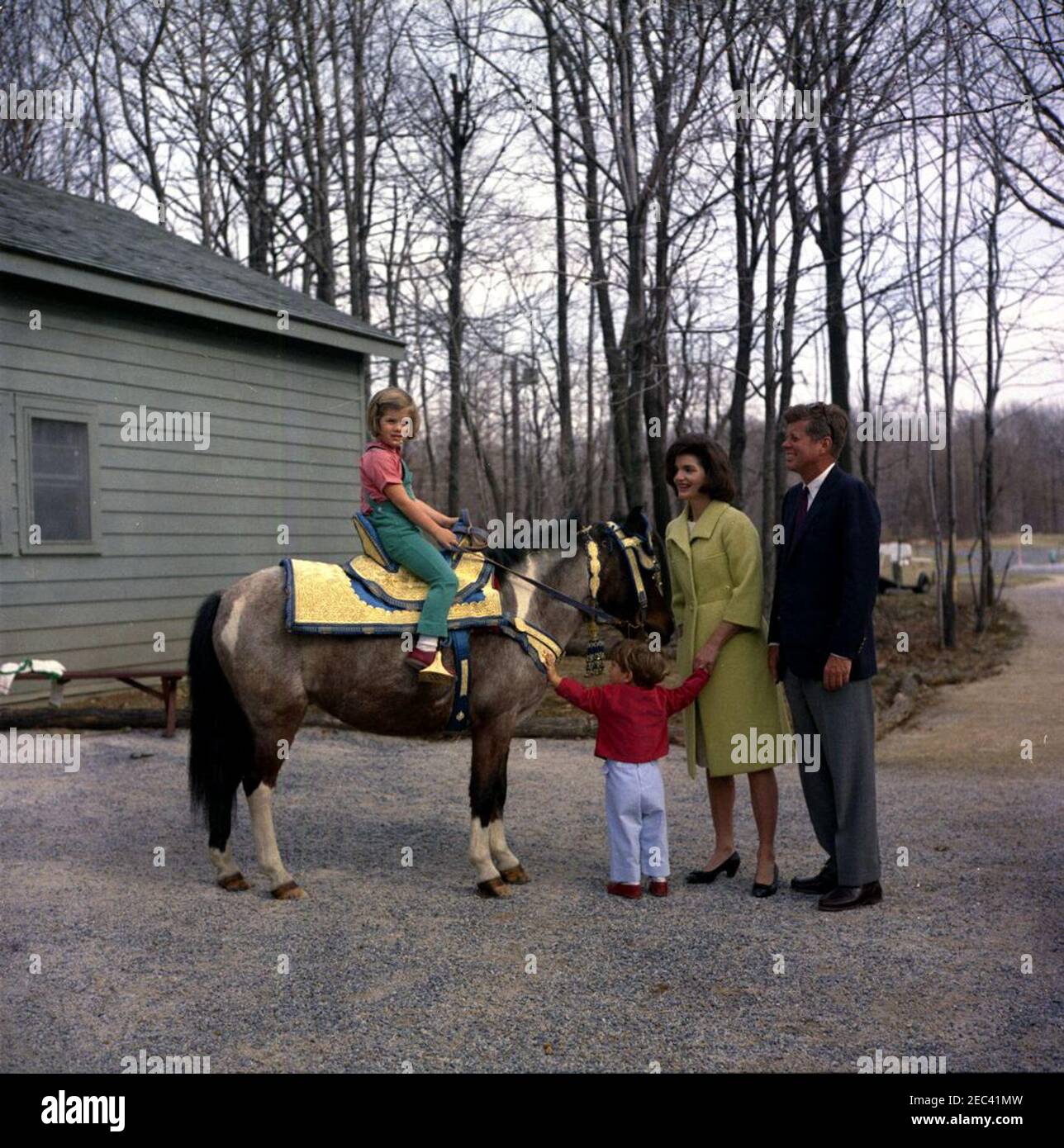 Weekend at Camp David. President John F. Kennedy and First Lady Jacqueline  Kennedy (both at right) pose with their children, Caroline Kennedy (sitting  astride her pony, u0022Macaroniu0022) and John F. Kennedy, Jr.,