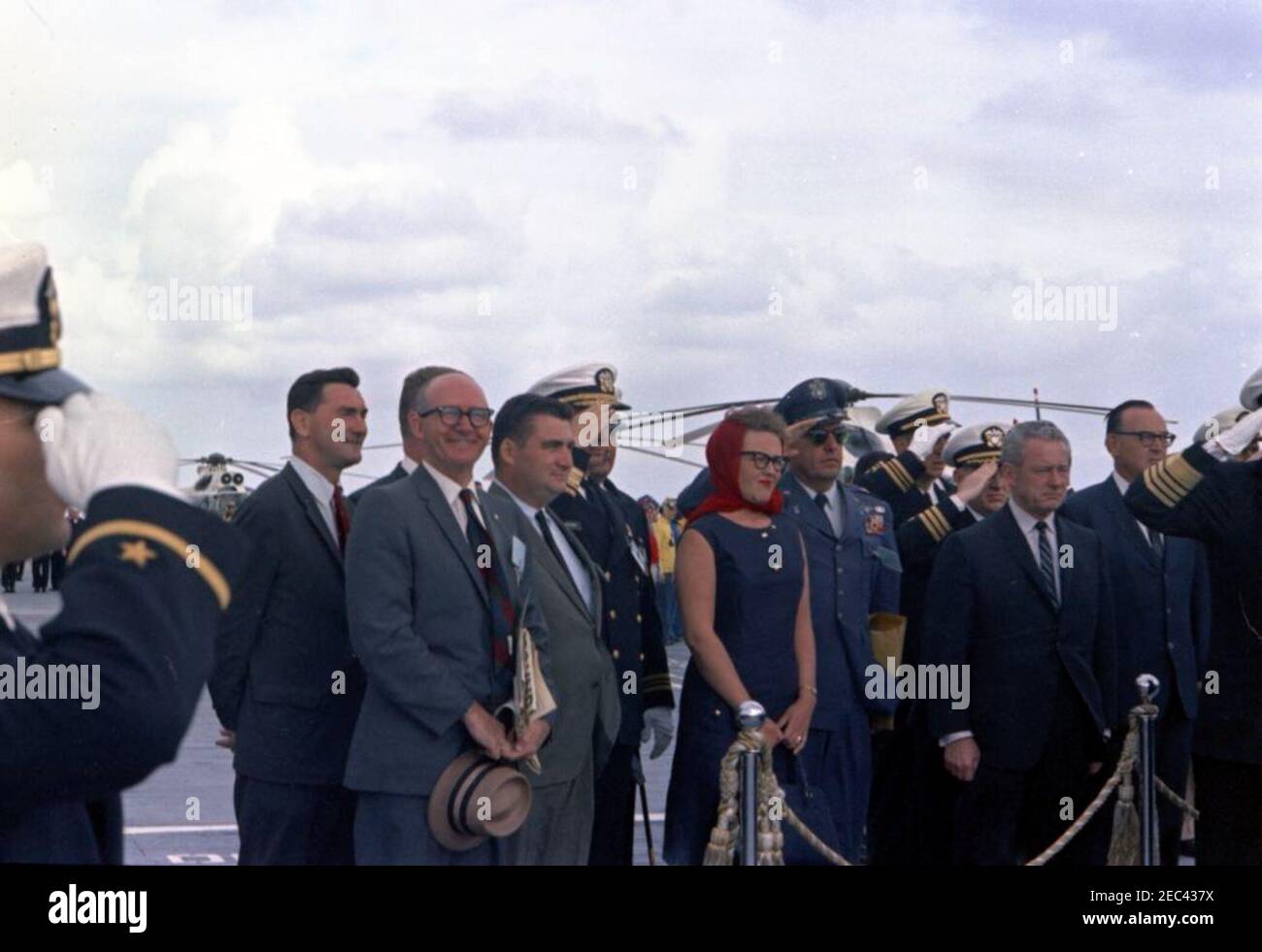 Trip to Western States: Visit to the Pacific Fleet, President Kennedy aboard the USS Oriskany, 4:00PM. View of guests standing left of reviewing platform aboard the flight deck of the aircraft carrier USS Oriskany (CVA-34) as ships from the task force perform a 21-gun salute in honor of President John F. Kennedyu0027s visit to the U.S. Pacific Fleet, at sea off the coast of San Diego, California. Those pictured include: Special Assistants to President Kennedy, Kenneth P. Ou0027Donnell and Dave Powers; Press Secretary, Pierre Salinger; Secretary to the Press Secretary, Sue Mortensen Vogelsing Stock Photo