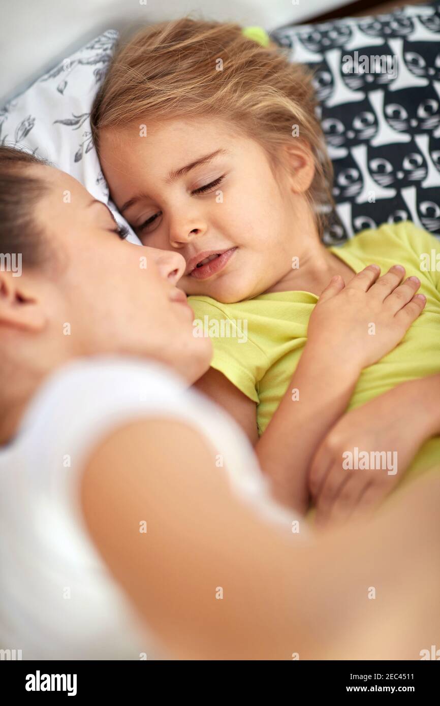 Mother and daughter sleeping together in the bed Stock Photo
