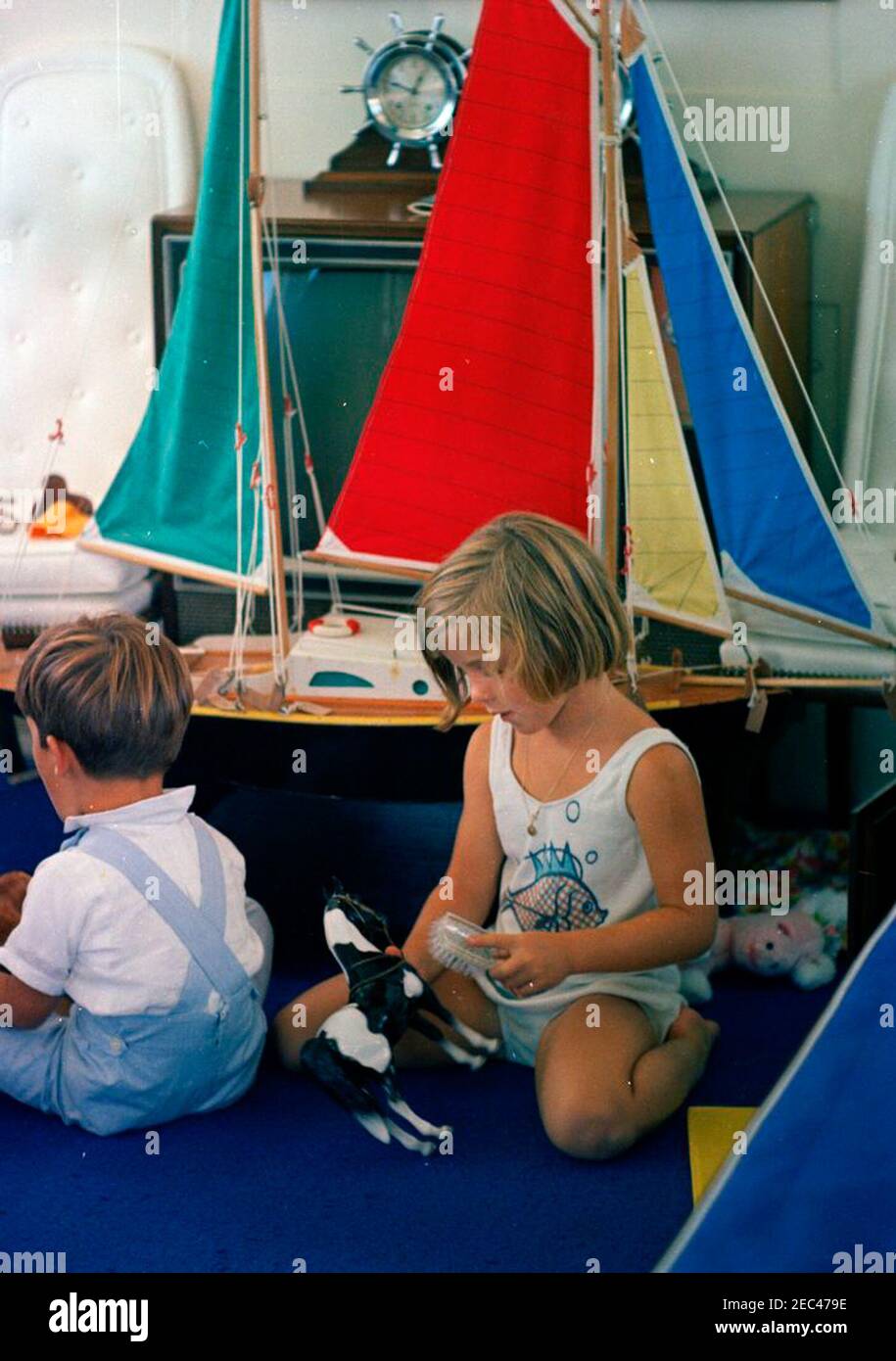 Labor Day weekend at Hyannis Port: Kennedy family and friends cruise aboard the Honey Fitz, 11:47AM. Caroline Kennedy and her cousin, Timothy Shriver, play with toys during Labor Day Weekend in Hyannis Port, Massachusetts. John F. Kennedy, Jr.u2019s toy boat, a gift from President Antonio Segni of Italy, sits in the background. Stock Photo