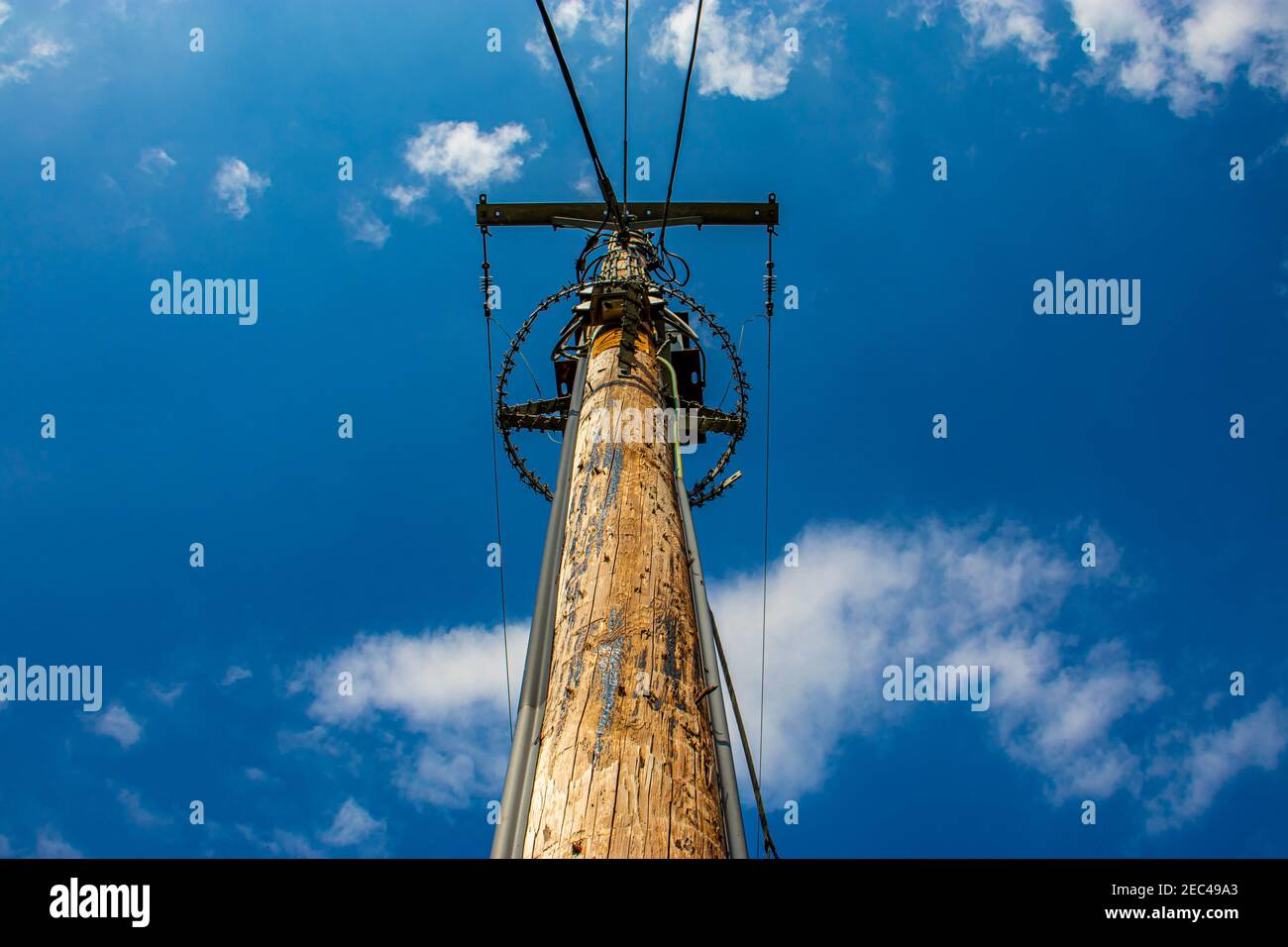 Electricity pole and wires with a cloudy blue sky Stock Photo - Alamy