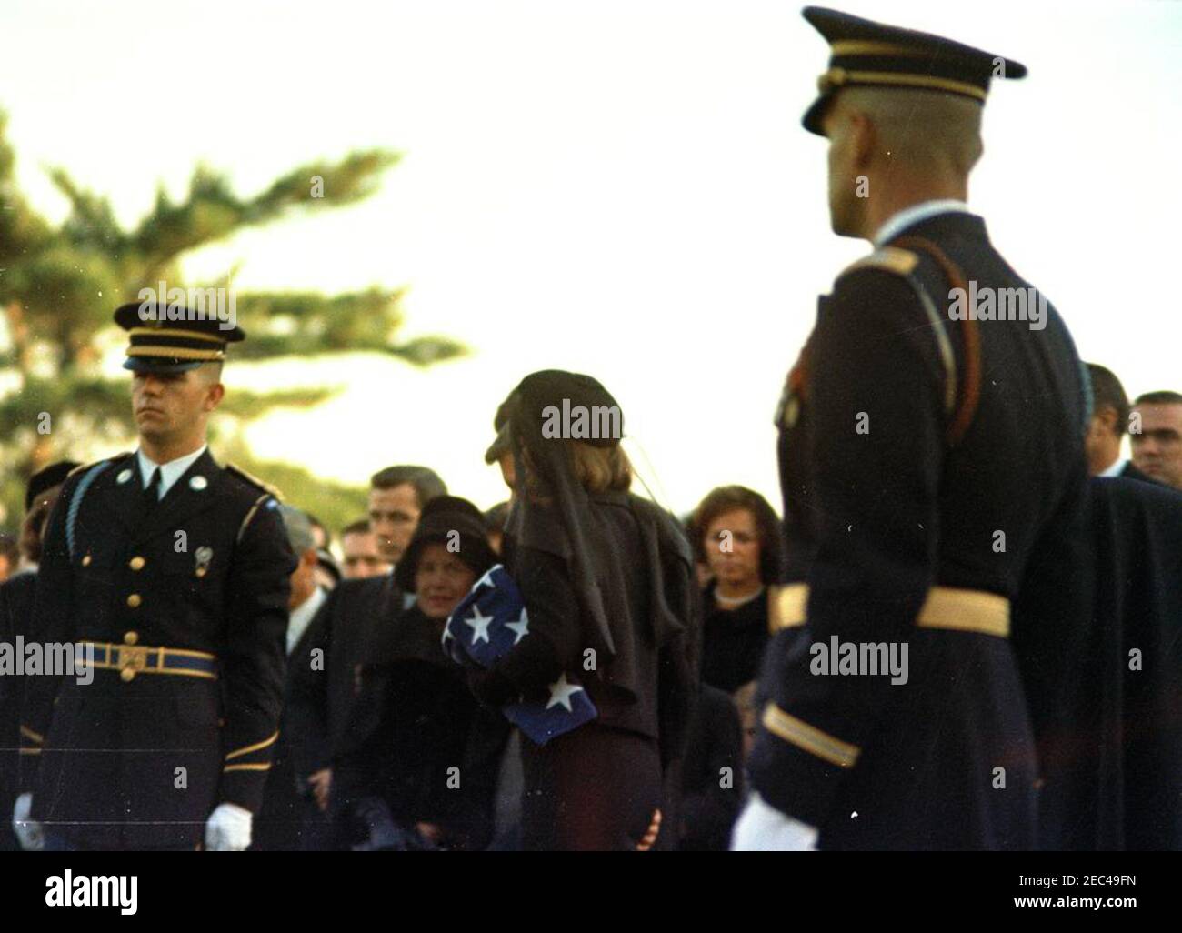 State Funeral of President Kennedy: Requiem Mass at St. Matthewu2019s Cathedral and burial at Arlington National Cemetery. Members of the Kennedy family attend graveside services in the state funeral of President John F. Kennedy; Jacqueline Kennedy (holding folded flag) and Attorney General, Robert F. Kennedy (mostly hidden), walk in center. Also pictured: Rose Fitzgerald Kennedy; Steve Smith; Ethel Skakel Kennedy; honor guard pallbearer, Corporal Douglas A. Mayfield (U.S. Army). Arlington National Cemetery, Arlington, Virginia. Stock Photo