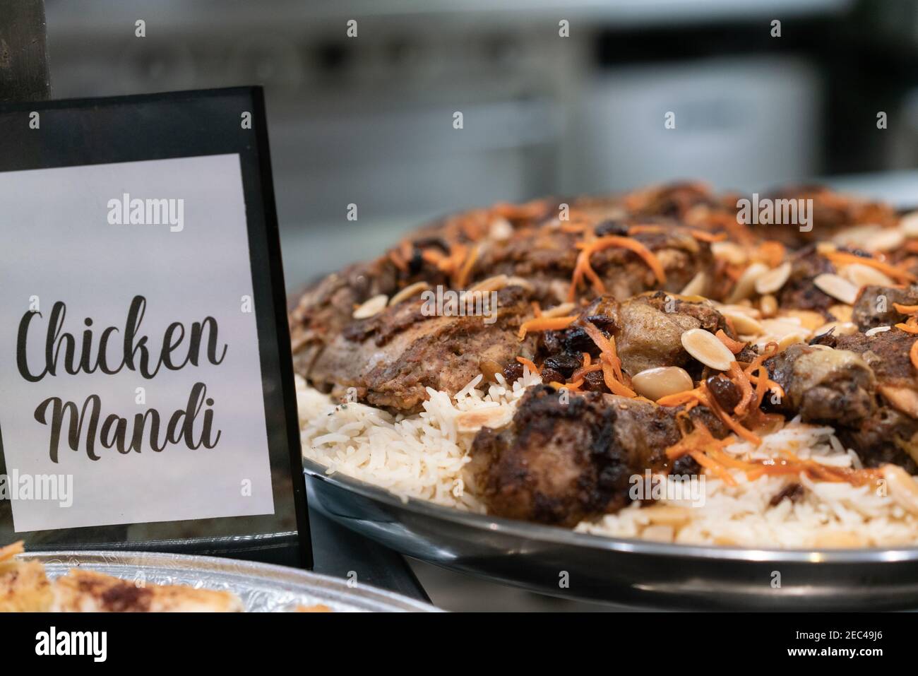 Closeup shot of a chicken dish on top of rice in a stainless steel ...