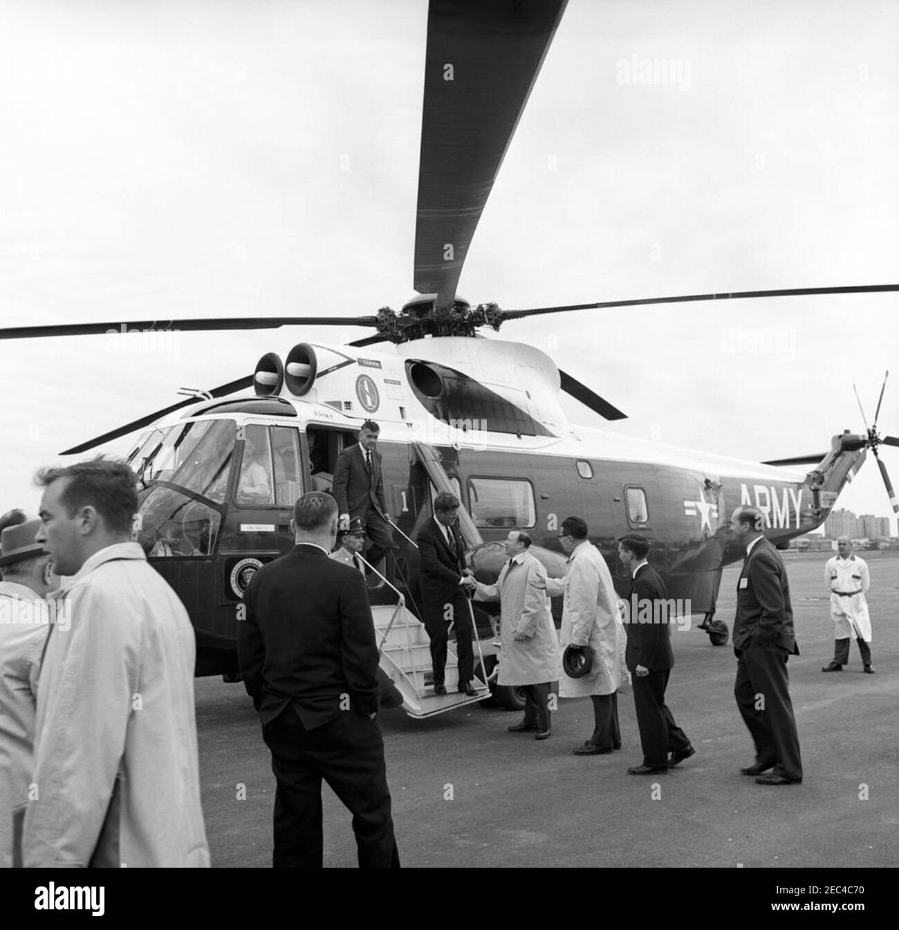 Arrival at and departure by helicopter from Bader Field, Atlantic City, New Jersey. President John F. Kennedy shakes hands with President of United Automobile Workers of America (UAW), Walter P. Reuther, upon arriving at Bader Field in Atlantic City, New Jersey. Governor of New Jersey, Richard J. Hughes, stands right of Mr. Reuther. Also pictured: United States Army presidential helicopter pilot, Barney Hulett; White House Secret Service agents, Dave Grant and Gerald A. u201cJerryu201d Behn. Stock Photo