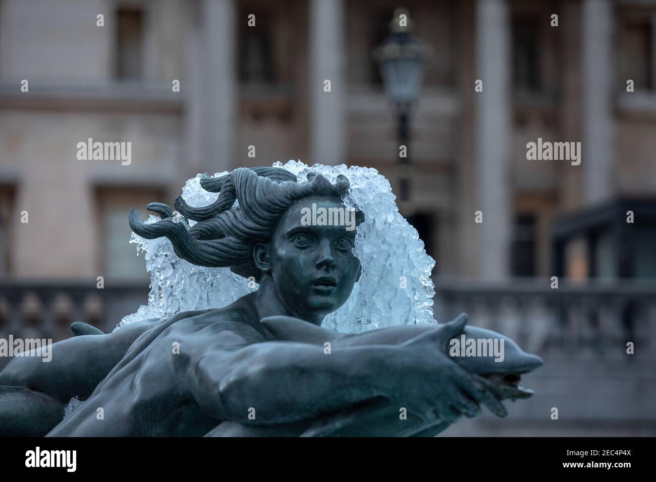 Frozen statue in Trafalgar Square in the foreground of National Gallery after temperatures hit sub-zero temperatures in London during February 2021. Stock Photo