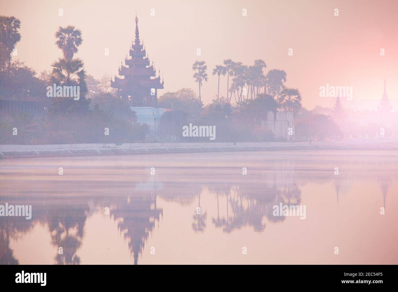 Ancient brown brick Palace wall with reflection in the canal surrounding the Mandalay palace located in Mandalay, Burma (Myanmar) at sunrise Stock Photo