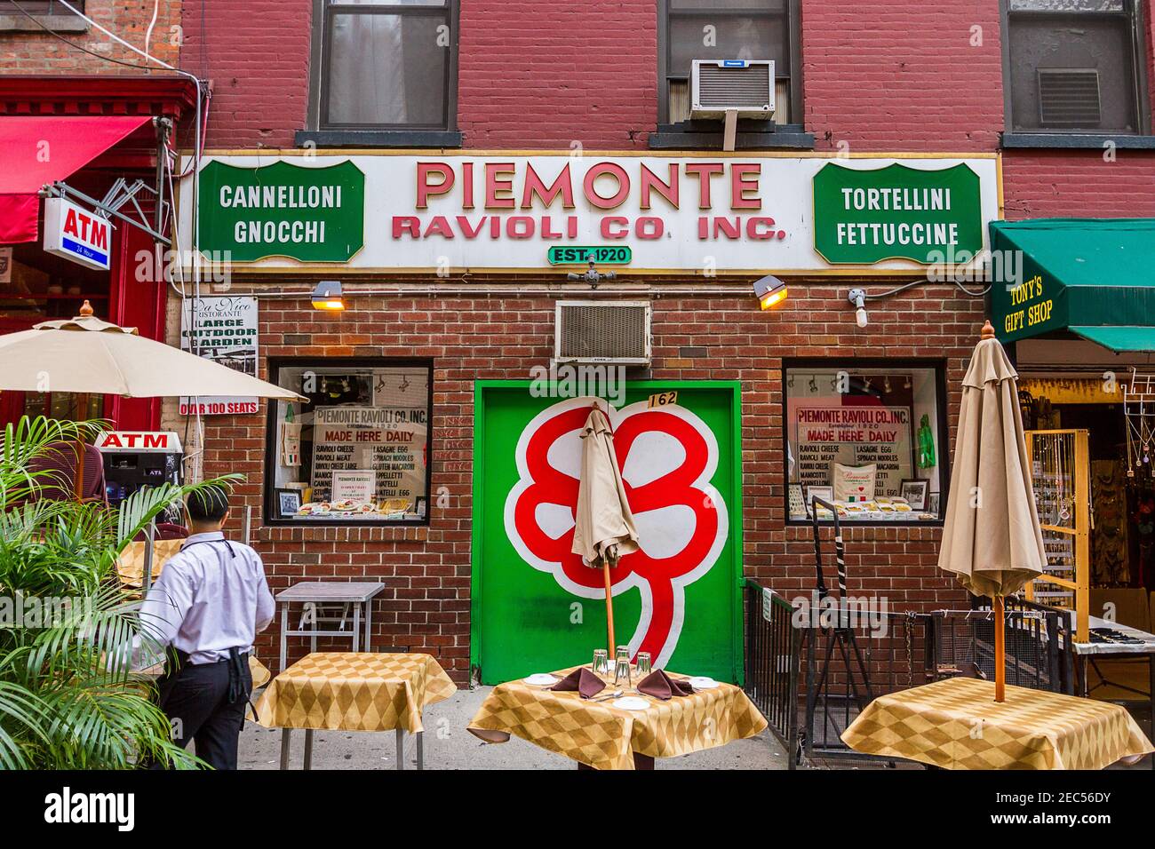 The sign of the Italian restaurant Piemonte Ravioli in Little Italy, Manhattan and the outdoor tables on the street Stock Photo