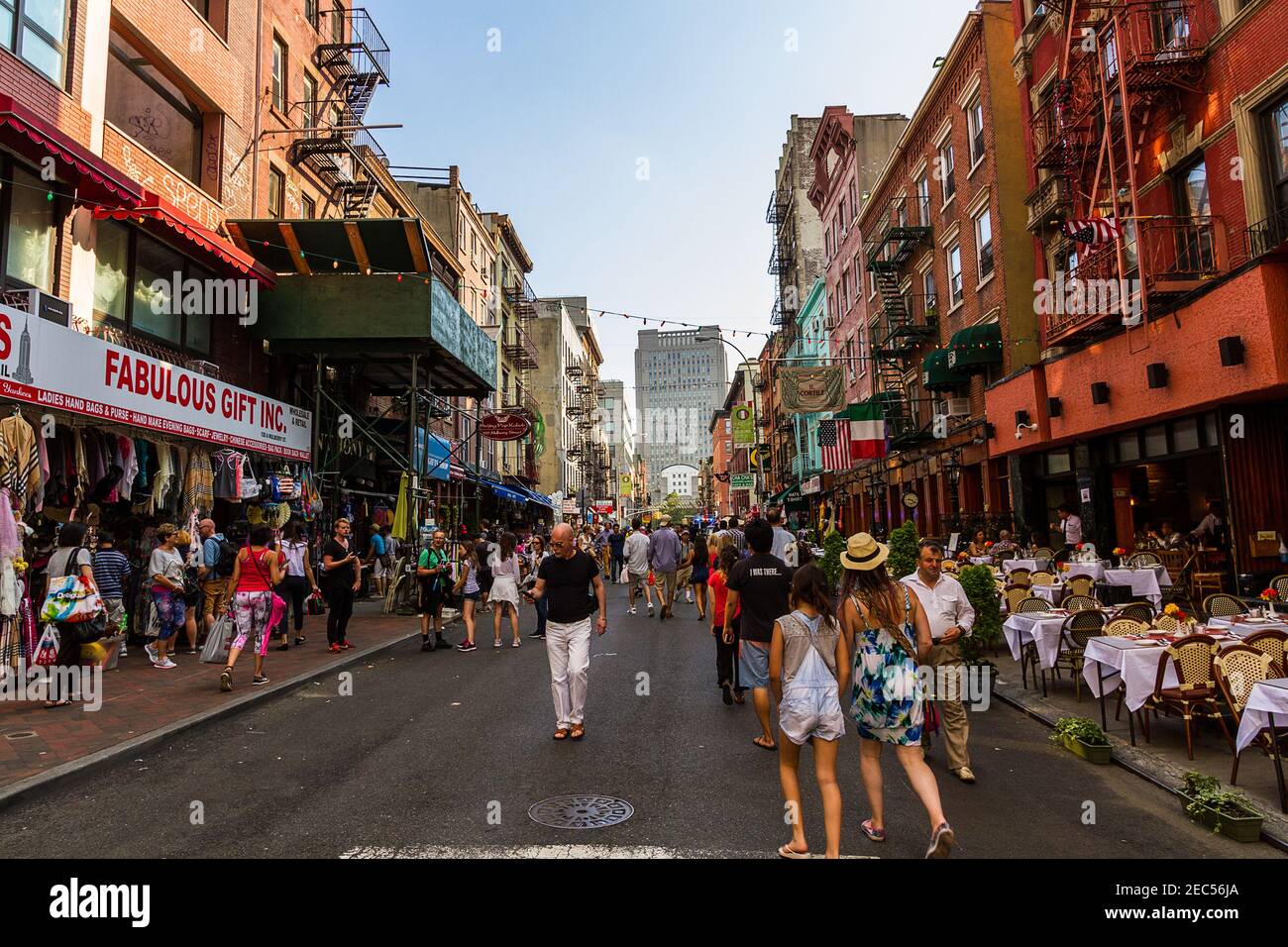 The view of Mulberry Street in Little Italy, Manhattan with tourists walking around the Italian restaurants and shops by the road Stock Photo