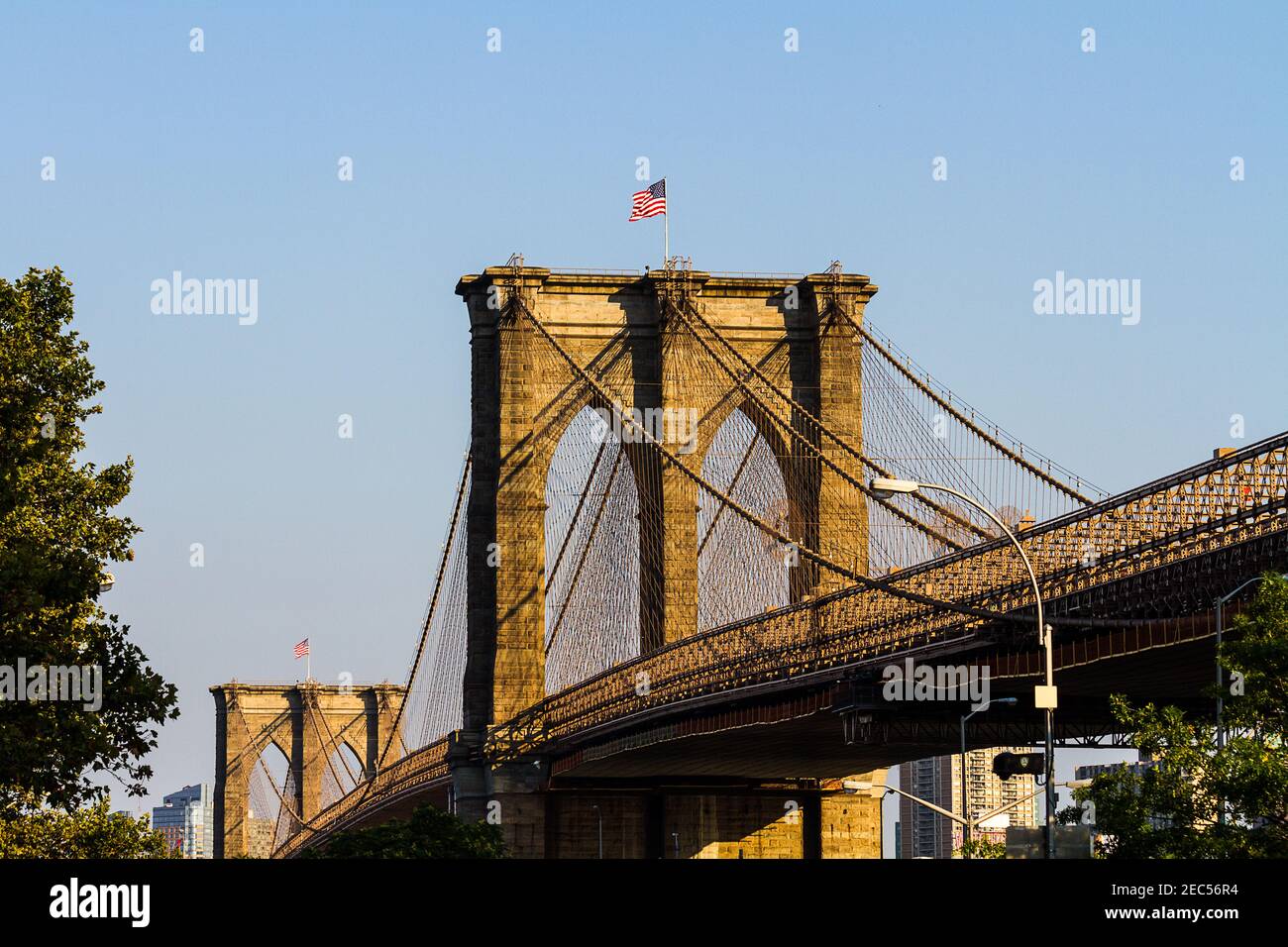 A close-up of the Brooklyn Bridge with the American flag on the top seen from Frankfort Street in Manhattan Stock Photo
