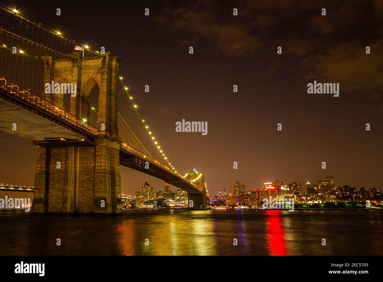 The night view of the Brooklyn Bridge with the city lights reflections on East River Stock Photo