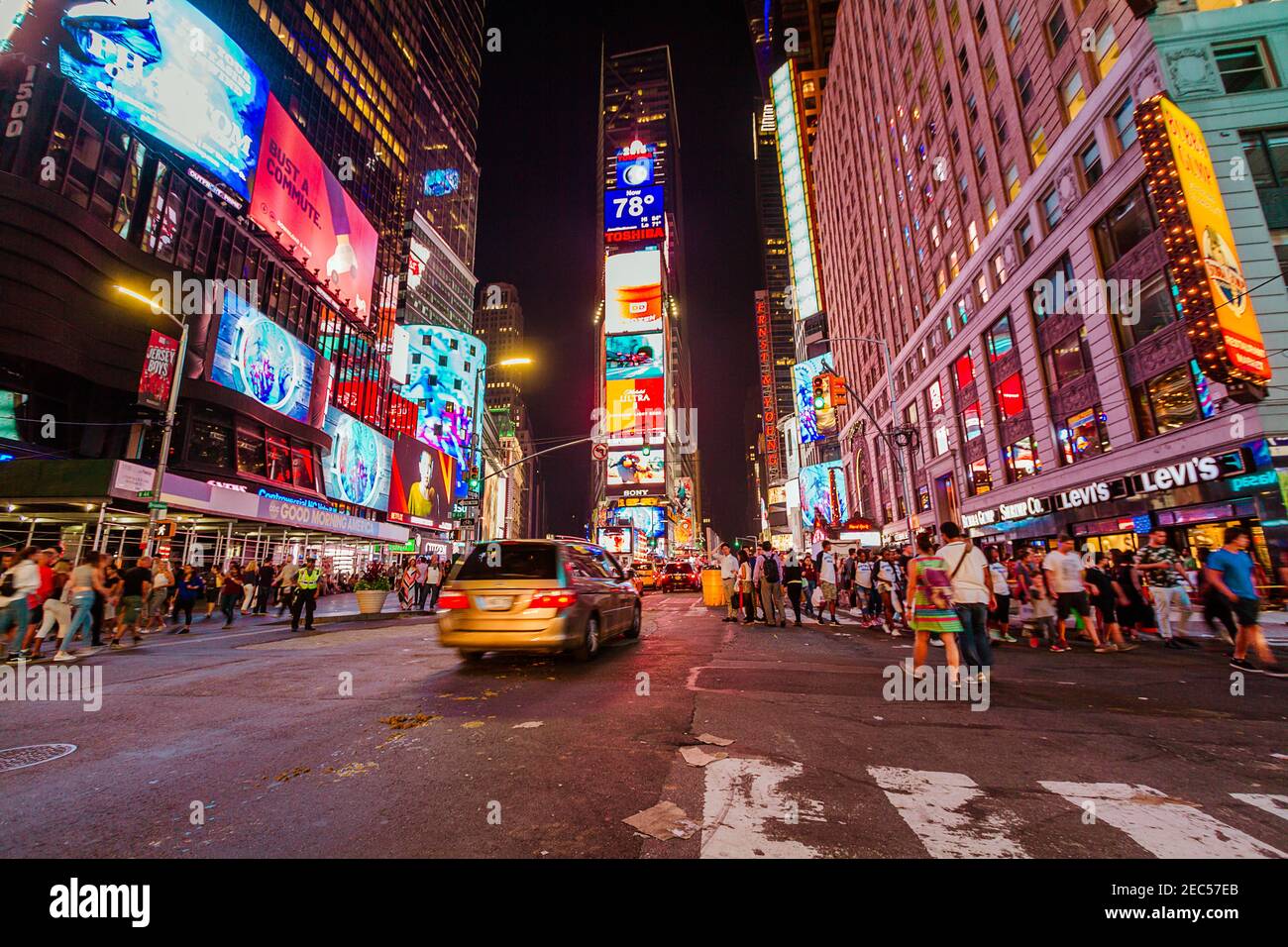Night traffic at Times Square with full of tourists, cabs and cars and a traffic agent crossing the street Stock Photo