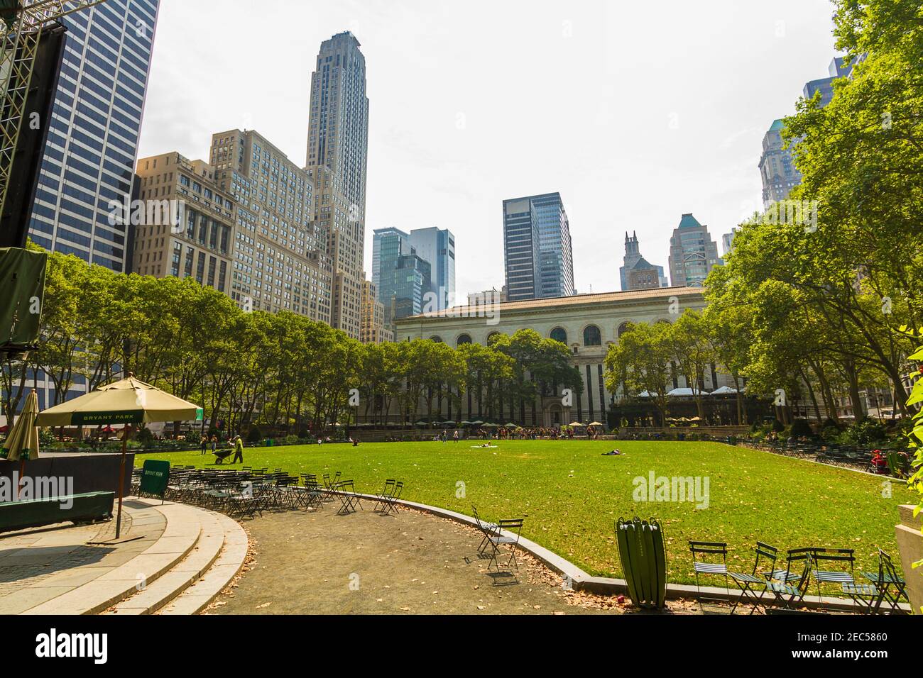 Empty tables and chairs at Bryant Park and New York Public Library main branch in the background on a summer day Stock Photo