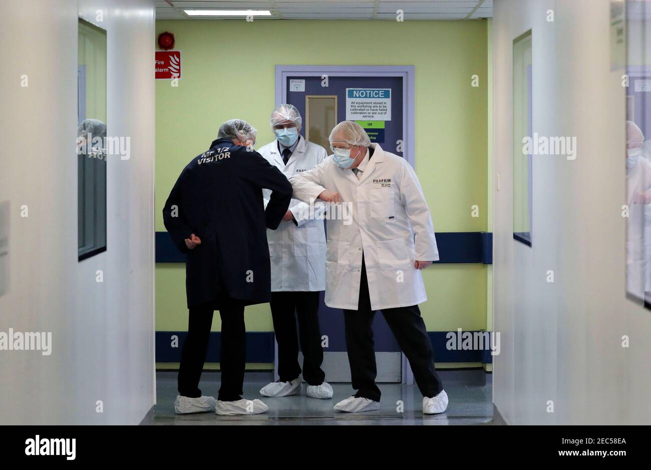 Prime Minister Boris Johnson wearing a face mask bumps elbows in