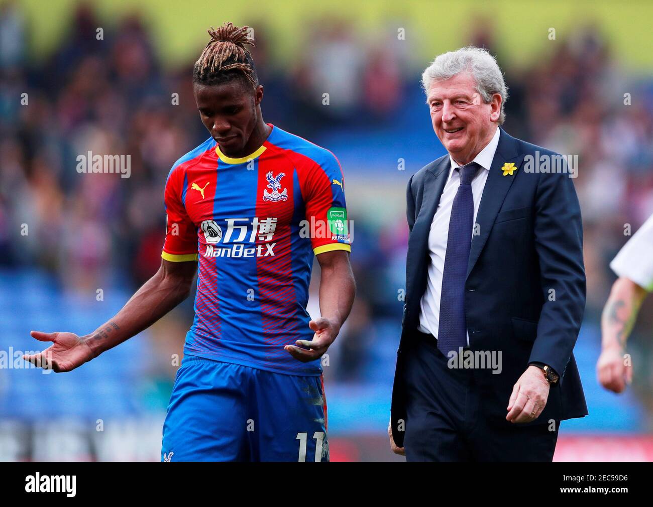 Soccer Football - Premier League - Crystal Palace v Huddersfield Town - Selhurst Park, London, Britain - March 30, 2019  Crystal Palace's Wilfried Zaha with manager Roy Hodgson after the match    Action Images via Reuters/Andrew Couldridge  EDITORIAL USE ONLY. No use with unauthorized audio, video, data, fixture lists, club/league logos or 'live' services. Online in-match use limited to 75 images, no video emulation. No use in betting, games or single club/league/player publications.  Please contact your account representative for further details. Stock Photo