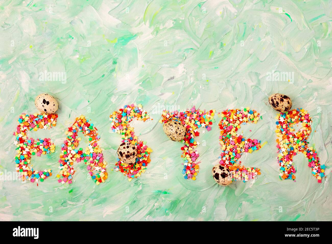 Easter text on a green background with brush strokes with quail eggs. Spring card. Copy space Stock Photo
