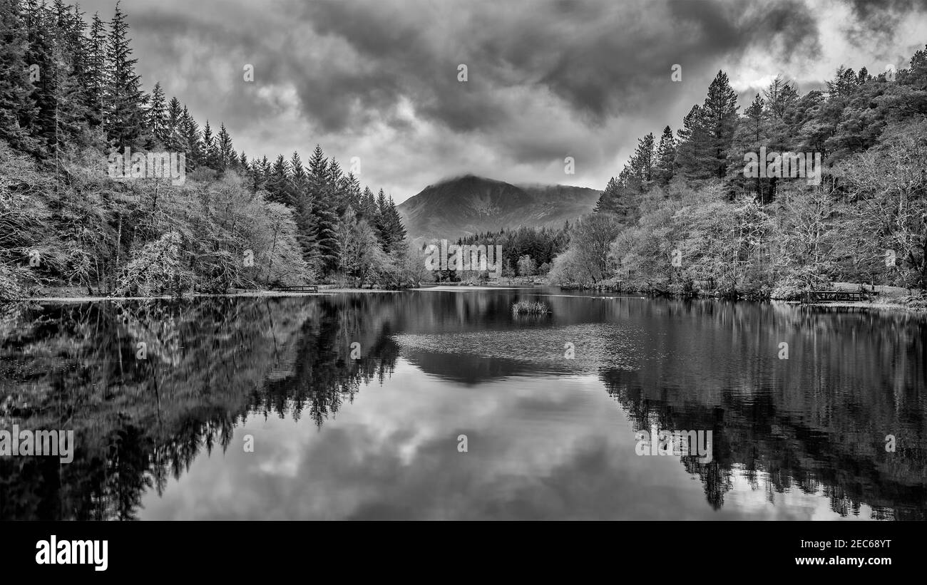 Beautiful  black and white landscape image of Glencoe Lochan with Pap of Glencoe in the distance on a Winter's evening Stock Photo