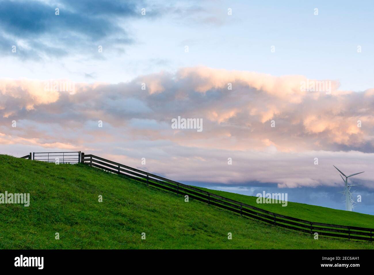 Polder landscape with wind turbines and fence under a beautiful clouded sky, late afternoon, Flevopolder, the Netherlands Stock Photo
