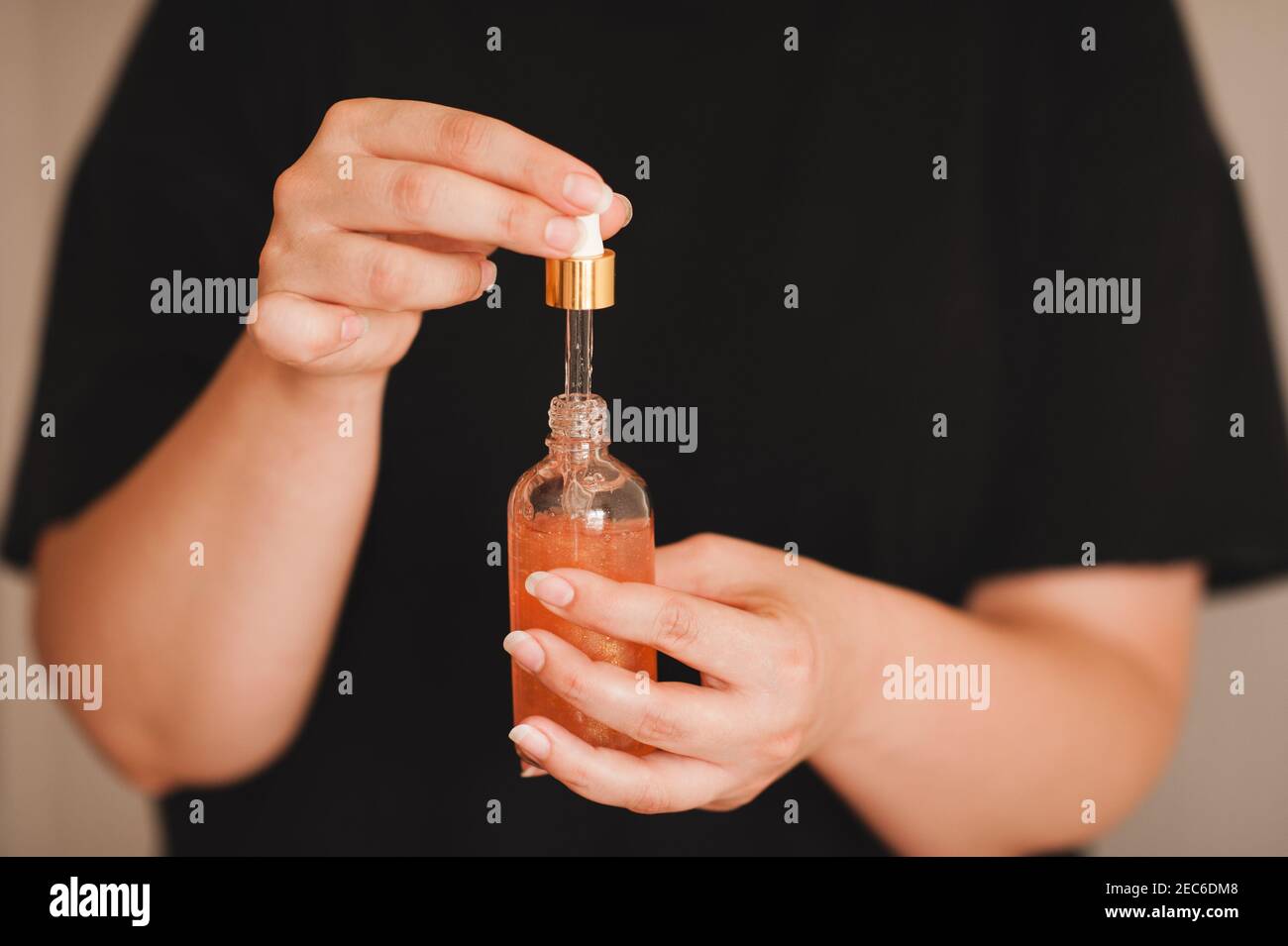 Woman holding moisturizing facial serum in glass bottle close up. Skin health care. Healthy lifestyle. Stock Photo