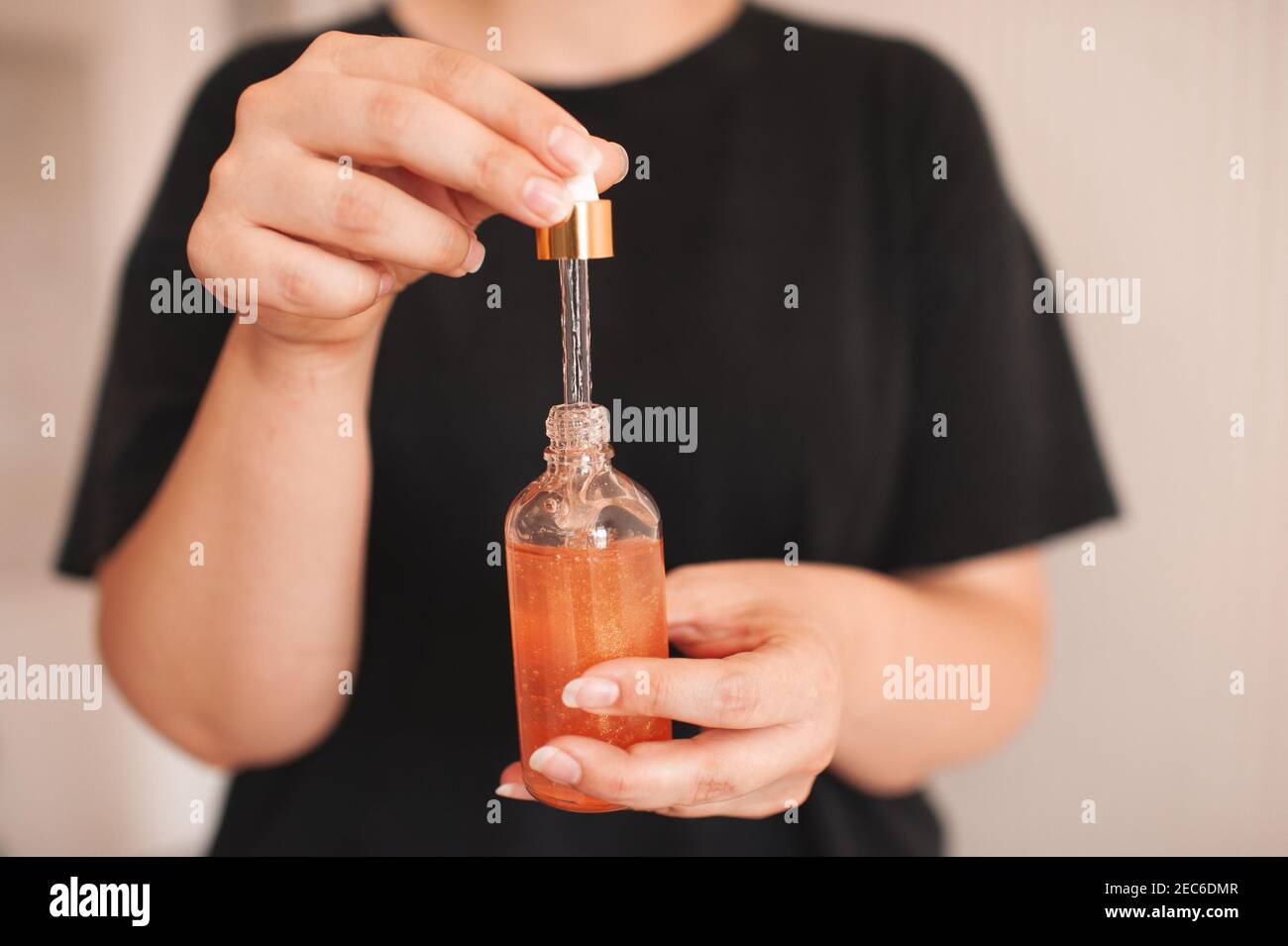 Woman holding moisturizing facial serum in glass bottle close up. Skin health care. Healthy lifestyle. Stock Photo