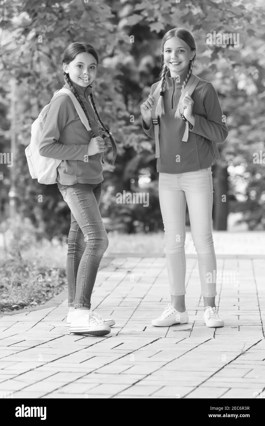 Teen kids with backpack. concept of friendship. best school friends. going to school with fun. schoolgirls with backpack. teenage girls with backpacks walking in park. Back to school. Stock Photo