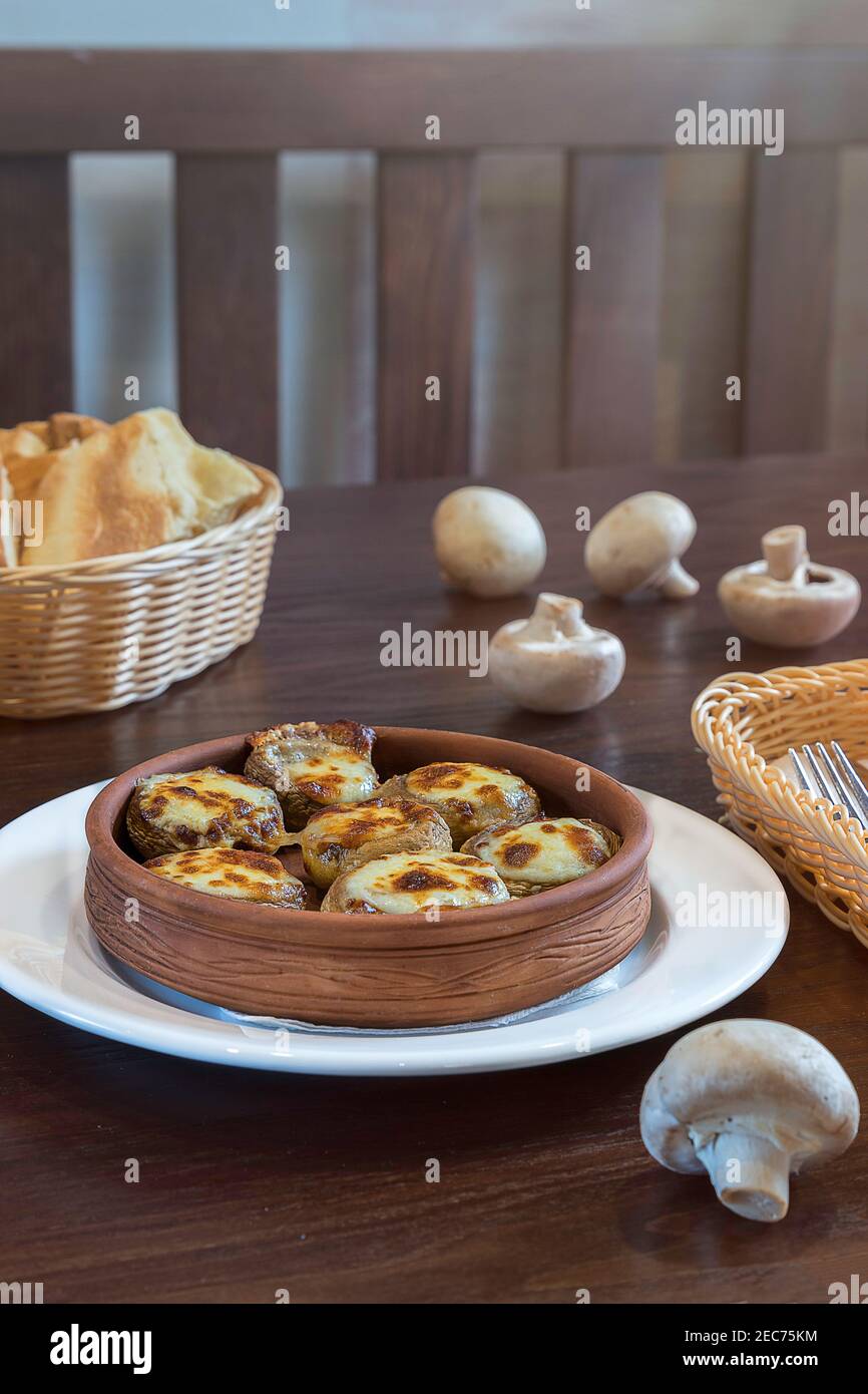 Mushrooms, Sulguni Cheese in Clay Pots on the table. Georgian traditional food Stock Photo