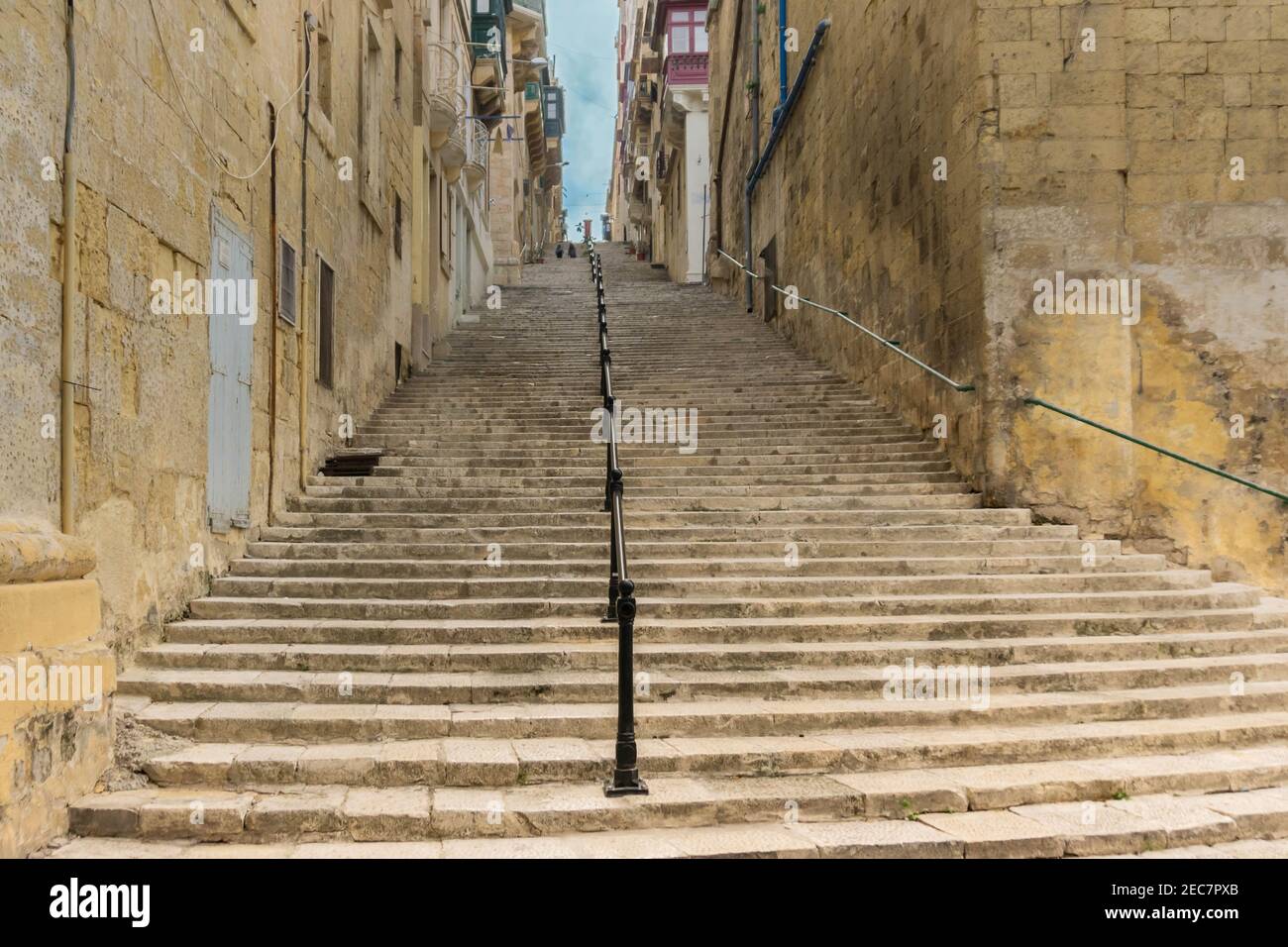 Typical narrow stone street with stairs in medieval old town Valletta, on island of Malta Stock Photo