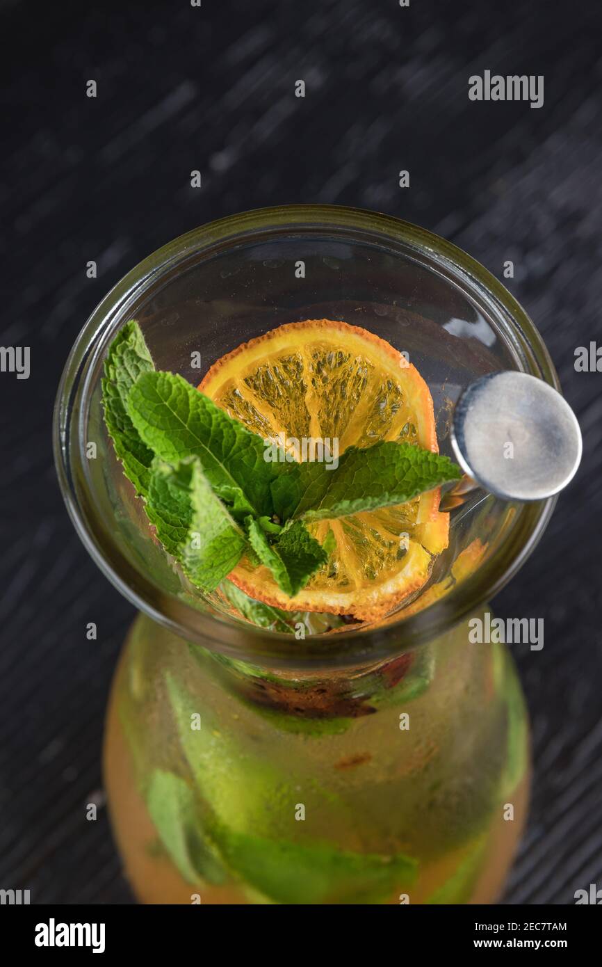 Lemonade drink of soda water, lemon and mint leaves in jar on black background Stock Photo