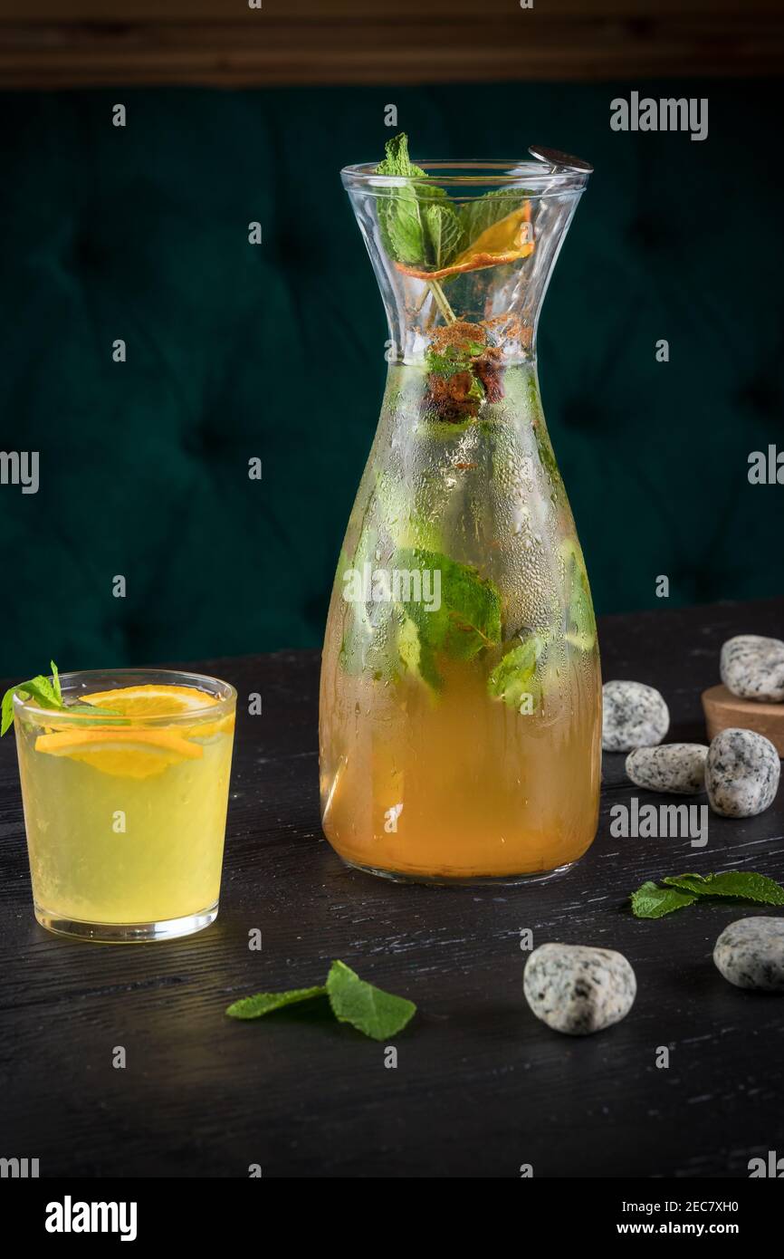 Lemonade drink of soda water, lemon and mint leaves in jar and glass on the black background Stock Photo