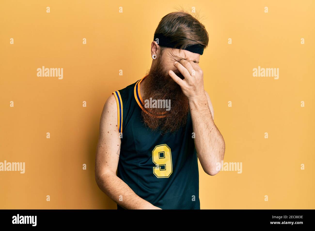 Redhead Man With Long Beard Wearing Basketball Uniform Tired Rubbing