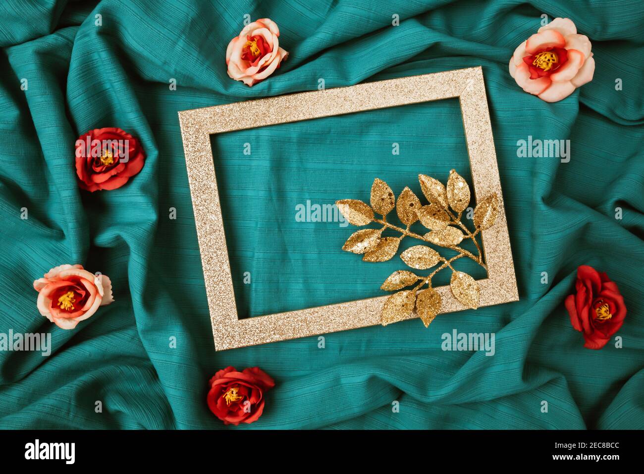 Layout of gold leaves with shiny frame and rose flowers. Creative cyan background. Minimal Valentines day concept Stock Photo