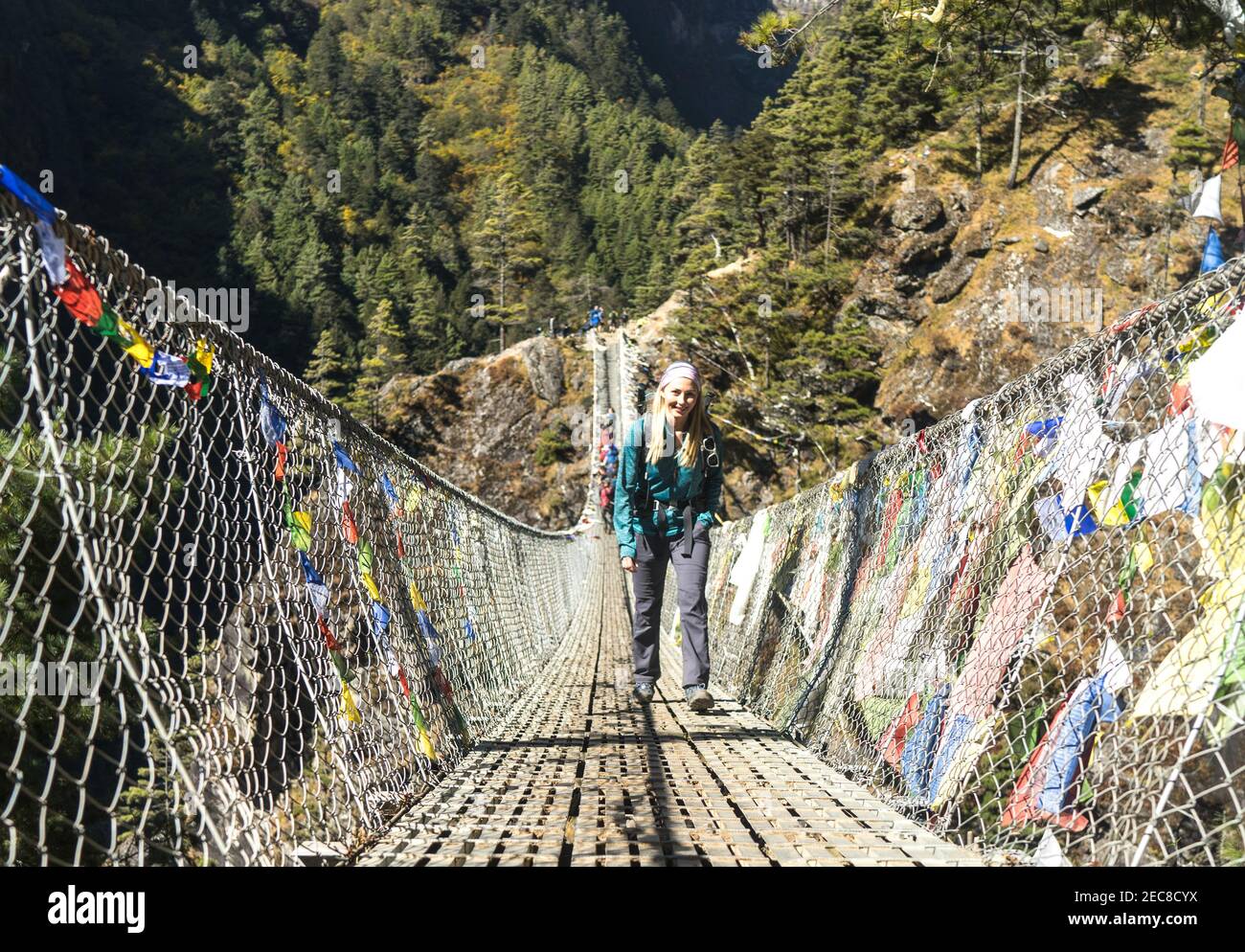 Happy female trekker on a suspension bridge in Nepal, Everest Base Camp