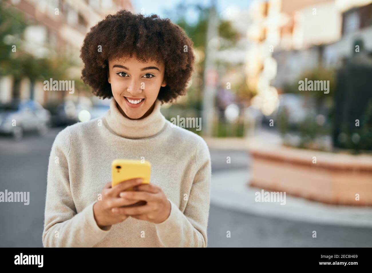 Young hispanic girl smiling happy using smartphone at the city Stock ...