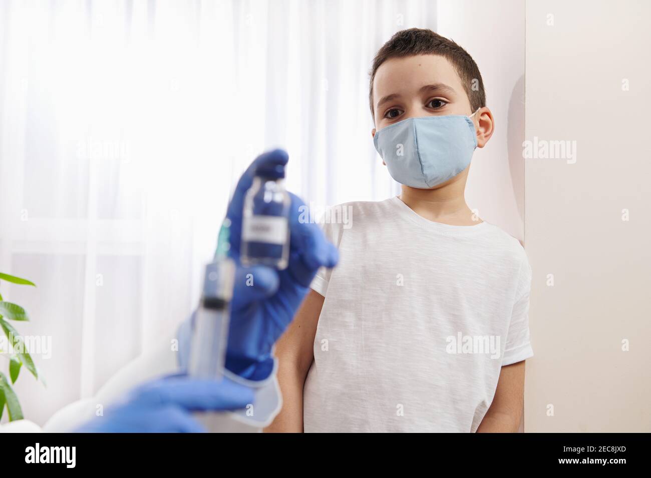 Little boy wearing medical mask looking at the hands of doctor holding ...