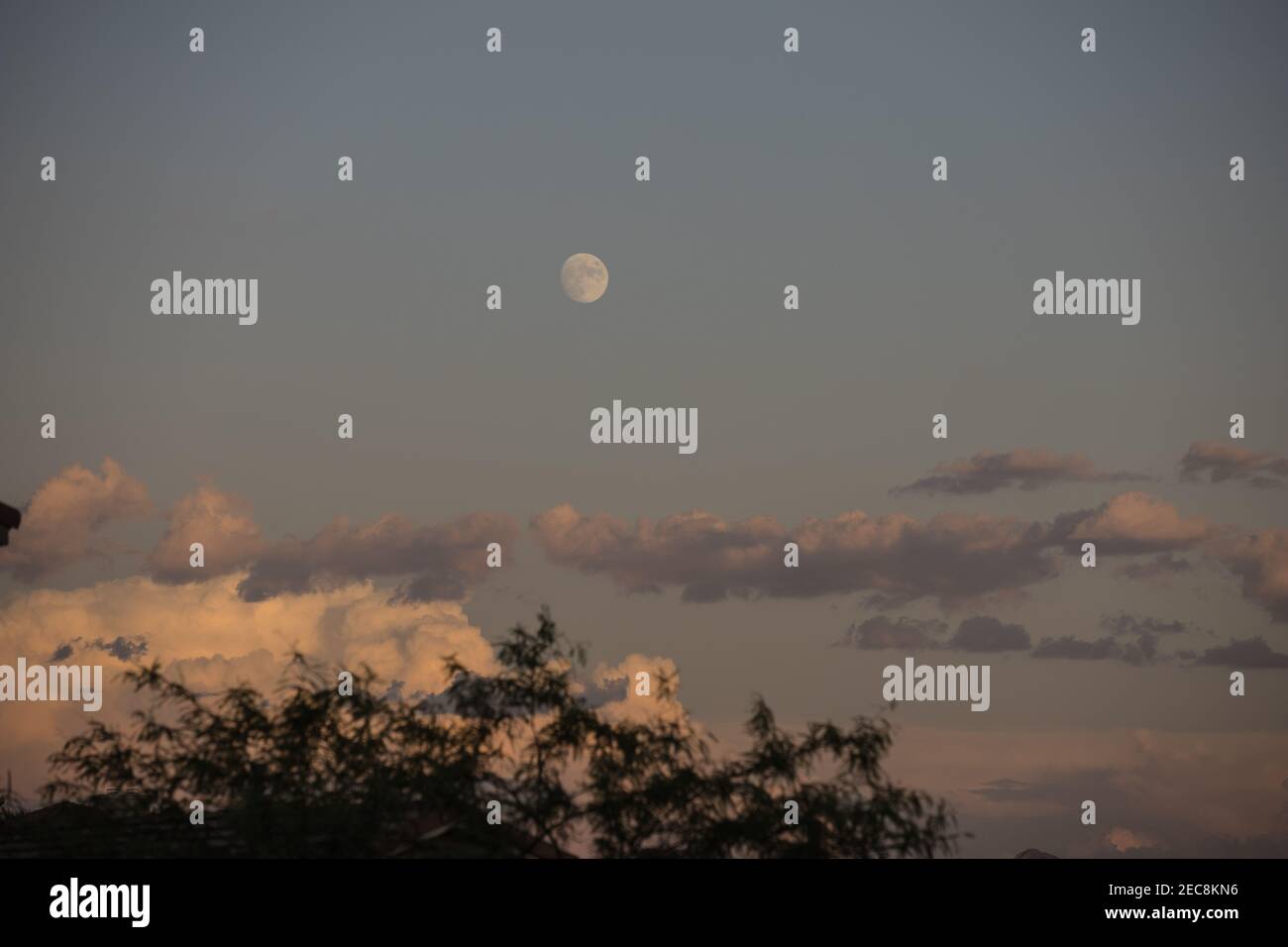 Distant waning moon and clouds Stock Photo