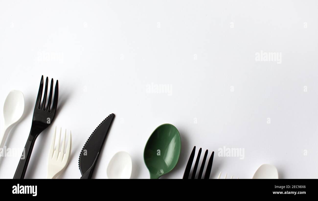 Disposable plastic cutlery on a white background. Place for text. Environmental problem