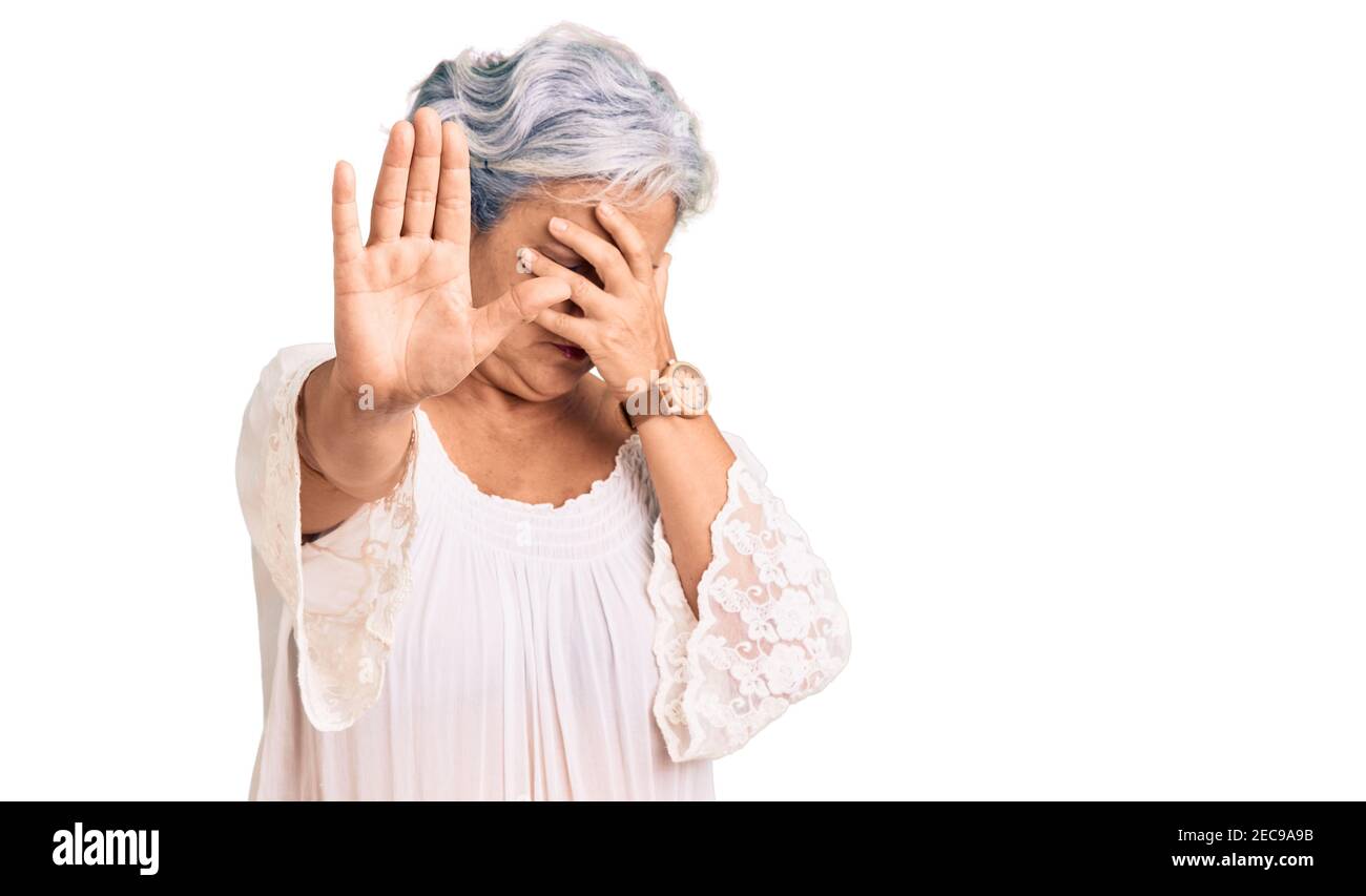 Senior woman with gray hair wearing bohemian style covering eyes with hands and doing stop gesture with sad and fear expression. embarrassed and negat Stock Photo