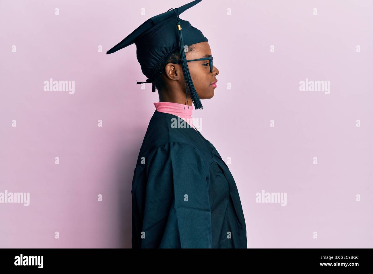 Young african american girl wearing graduation cap and ceremony robe  looking to side, relax profile pose with natural face and confident smile  Stock Photo - Alamy