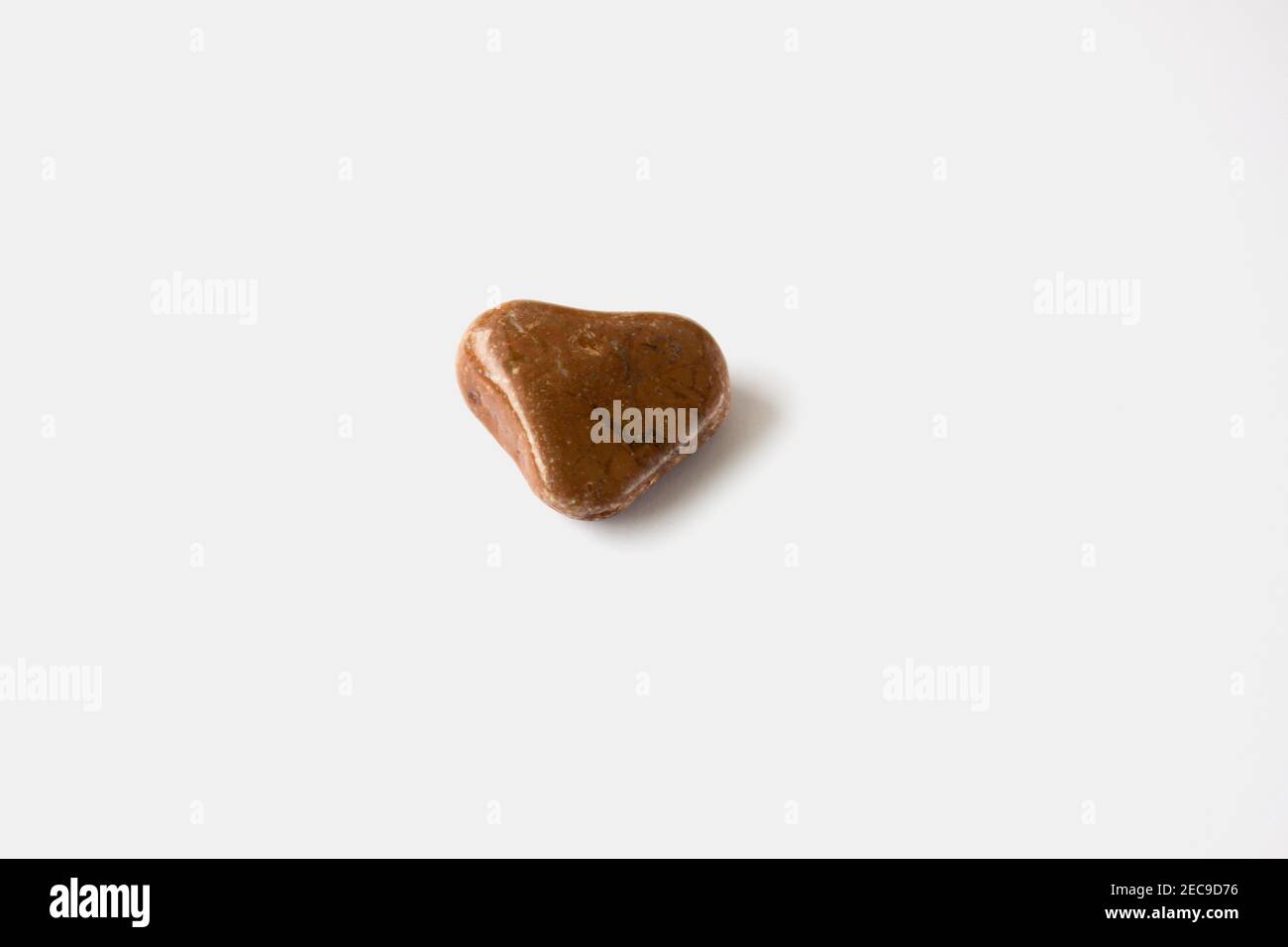 Brown stone in the shape of a heart on a white background. Stock Photo