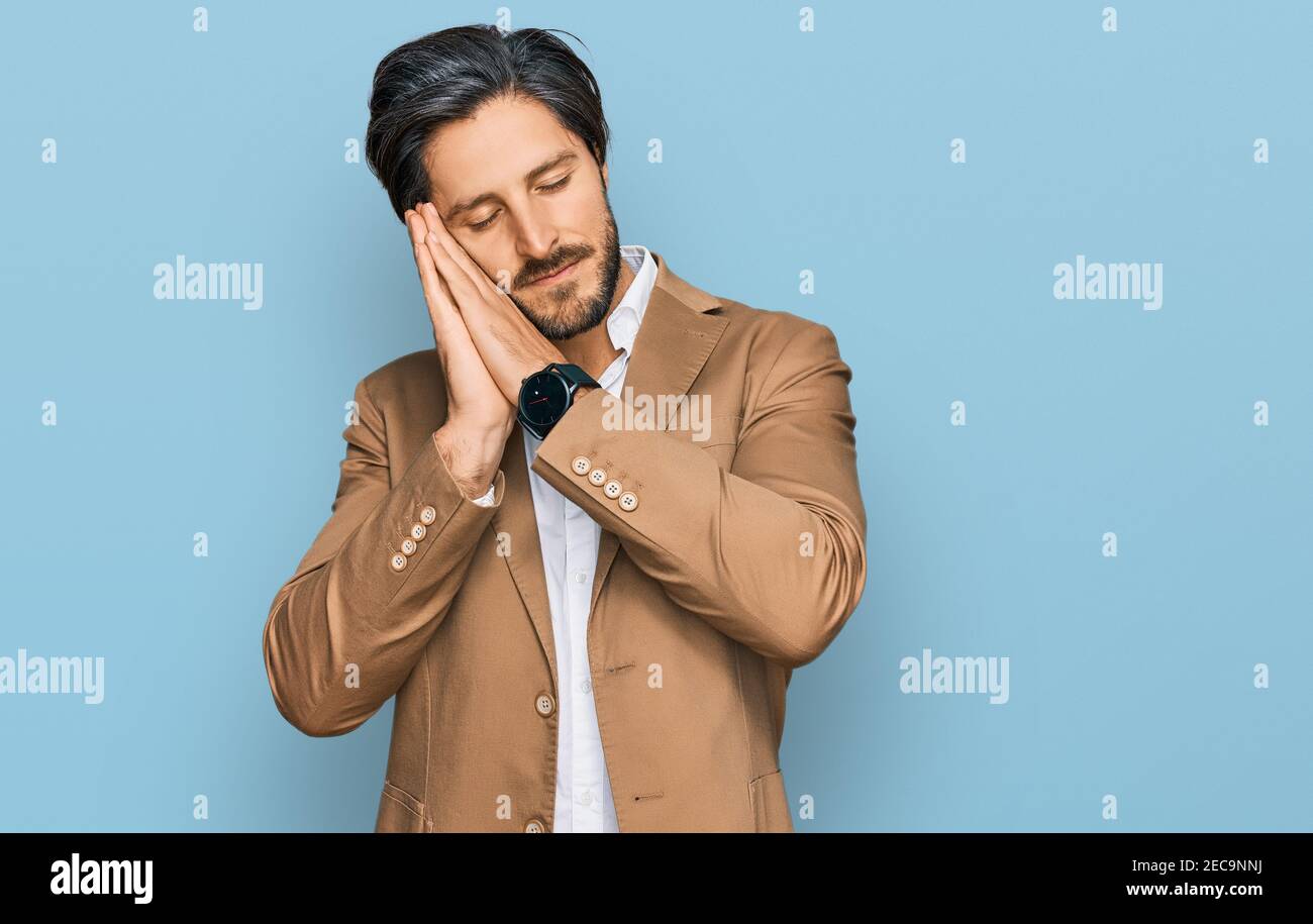 Young hispanic man wearing business clothes sleeping tired dreaming and ...