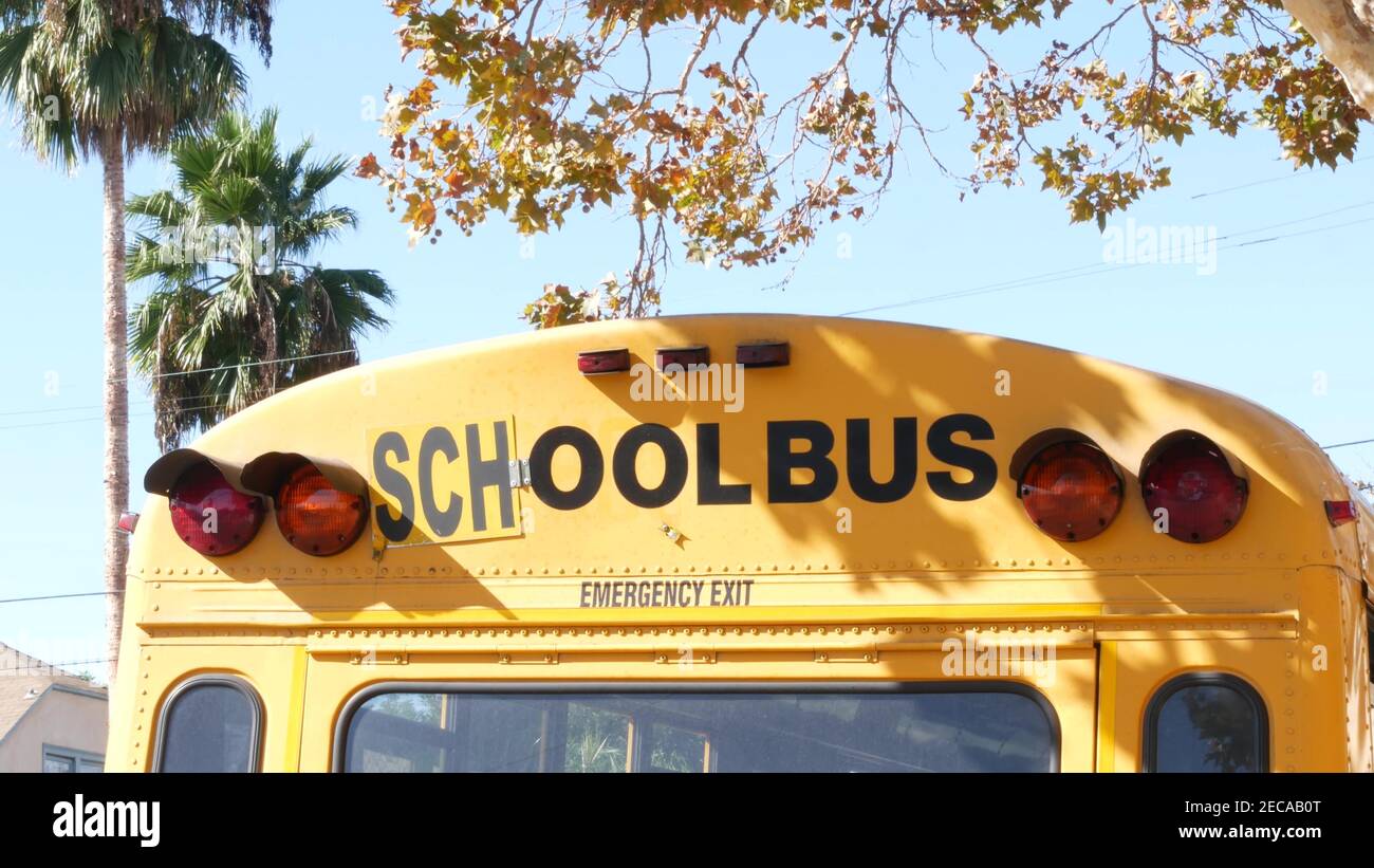 Yellow iconic school bus in Los Angeles, California USA. Classic truck for students back view. Vehicle stoplights for safety of children transportatio Stock Photo