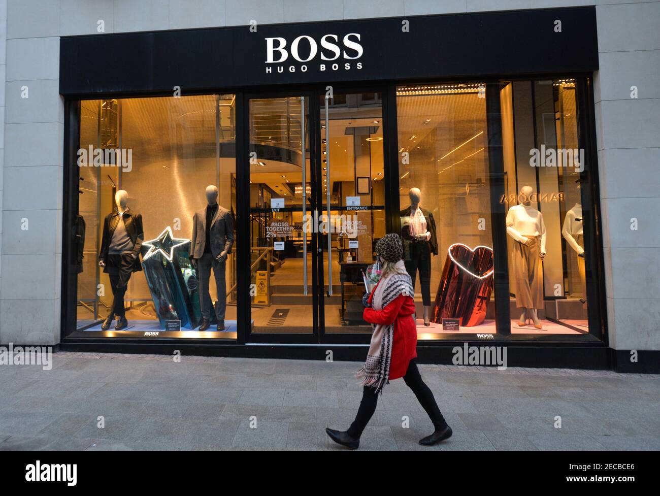 A woman walks by a closed Hugo Boss store on Grafton Street in Dublin city  center, during the COVID-19 pandemic lockdown.Level 5 lockdown restrictions  are set to be extended by Irish Government,