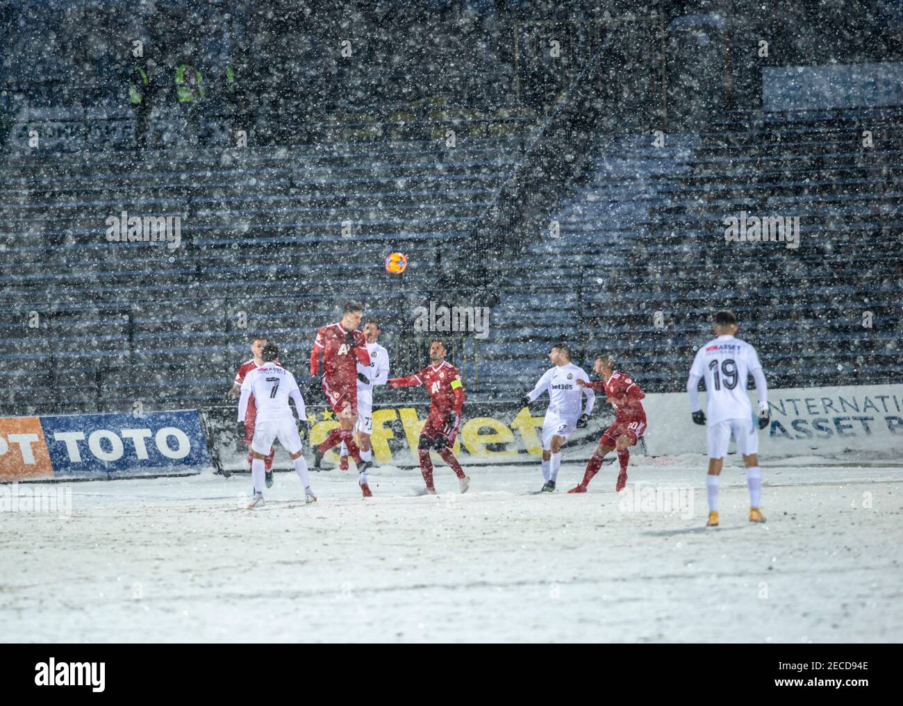 Sofia, Bulgaria - Feb 13 2021: Dense snowfall and hard conditions for CSKA and Slavia players on Slavia staduim Stock Photo
