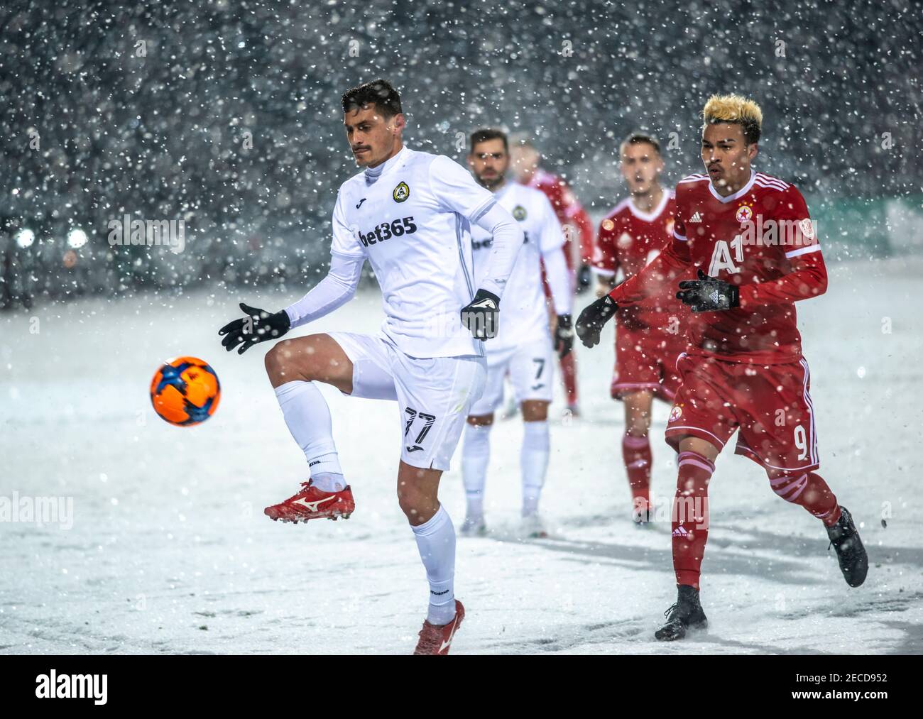 Sofia, Bulgaria - Feb 13 2021: Vulchev playing with the ball followed by Penaranda during a snowy football match between CSKA Sofia and Slavia Stock Photo
