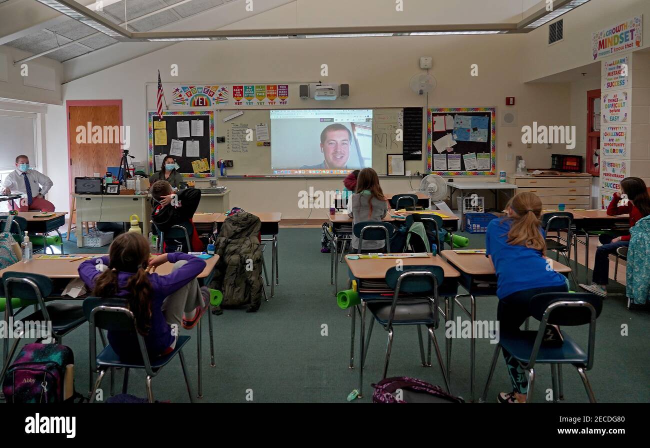 After a possible Covid-19 exposure revealed through contact tracing, a fifth grade teacher speaks to his students in the classroom from a remote locat Stock Photo