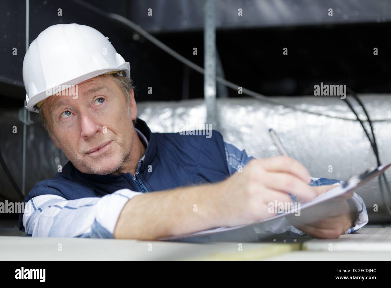 mature man construction worker reading on clipboard Stock Photo