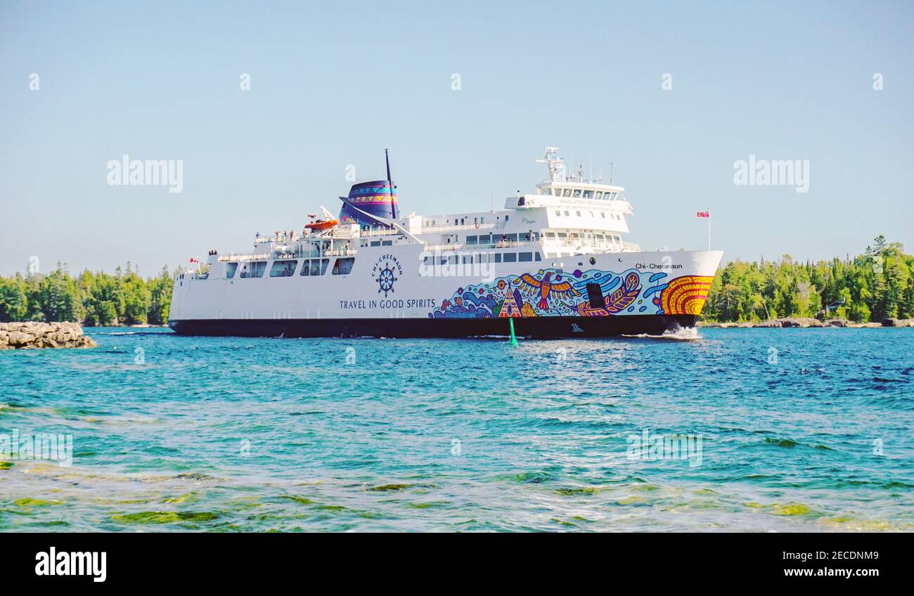 Ms Chi-Cheemaun ferry, decorated with colorful indigenous art on its body, departs Manitoulin Island and sails on the blue water of Georgian Bay, Onta Stock Photo