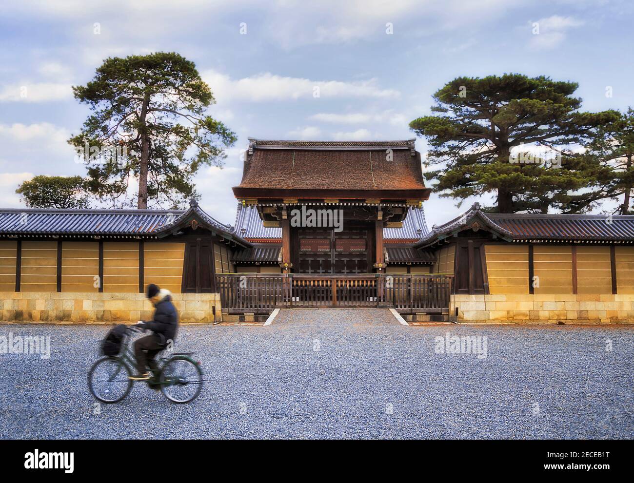 Blurred lonely bicycle rider in front of historic gates to ancient imperial palace in Kyoto city of Japan. Stock Photo