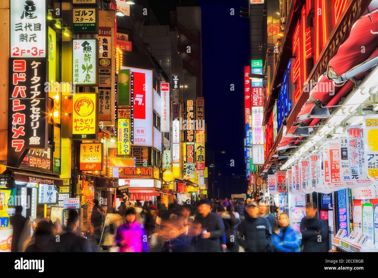 Tokyo, Japan - 2 January 2020: Famous shopping street with bright walls of flashing ads in Shinjuku district at night with bright illumination. Stock Photo