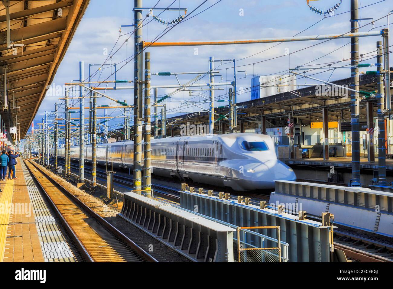 Express train passing railway station platforms in Shin-Fuji city of Japan on a sunny day. Stock Photo
